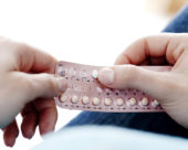 A woman holding contraceptive pills